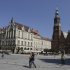 Tourists walk through the main square with the Town Hall on the right in Wroclaw, Poland, in this  Aug. 18, 2011 photo. The latest backdrop for European financial crisis talks was Wroclaw, Poland _ or Breslau, as the picturesque city on the Oder River is still known in Germany. As Europe's finance chiefs bounce from meeting to meeting trying to hash out a strategy to contain their debt troubles, the city's history may serve as a reminder of what is at stake: a hard-won European unity that followed centuries of ravaging wars and has slowly enveloped the former Communist states in the continent's east.  (AP Photo/Czarek Sokolowski)