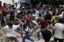 Pakistani, Iranian and Afghani migrants scuffle outside the police station of the city of Kos