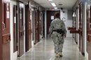 A guard walks through a cellblock inside Camp V, a prison used to house detainees at Guantanamo Bay U.S. Naval Base