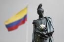 Flowers decorate the statue of independence hero Simon Bolivar at the main square in downtown Bogota, Colombia, Friday, Oct. 7, 2016. President Juan Manuel Santos won the Nobel Peace Prize Friday, just days after voters narrowly rejected a peace deal he signed with rebels of the Revolutionary Armed Forces of Colombia, FARC. (AP Photo/Fernando Vergara)