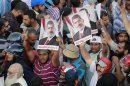 Supporters of deposed Egyptian President Mursi hold posters during a protest in Cairo