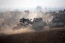 Israeli soldiers on Merkava tanks in an army deployment area near Israel's border with the Gaza Strip on July 12, 2014