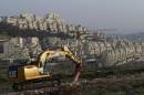 A bulldozer is seen next to a new housing construction site in the Israeli settlement of Har Homa (background) in east Jerusalem on March 19, 2014