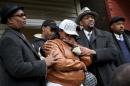 LaTarsha Jones, center, the daughter of Bettie Jones, is comforted by family and friends during a news conference on Sunday, Dec. 27, 2015, in front of the house where Bettie Jones was killed Saturday in the West Garfield Park neighborhood of Chicago. Grieving relatives and friends of two people shot and killed by Chicago police said Sunday that the city's law enforcement officers had failed its residents. (Nancy Stone/Chicago Tribune via AP) MANDATORY CREDIT