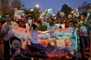 Supporters of the Iranian presidential candidate Hasan Rowhani, former Iranian nuclear negotiator, chant slogans, as they hold a banner containing pictures of Rowhani, center, former Presidents Akbar Hashemi Rafsanjani, right, and Mohammad Khatami, during a street campaign, in Tehran, Iran,Wednesday, June 12, 2013. The presidential election will be held on June 14. (AP Photo/Ebrahim Noroozi)