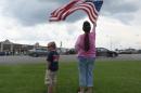 Cheryl Jenkins waves an American flag next to Zachary Meadows across from the Armed Forces Career Center on Lee Highway, Sunday, July 19, 2015, in Chattanooga, Tenn. Muhammad Youssef Abdulazeez attacked two military facilities, including the career center, last week in a shooting rampage that killed a U.S. Navy sailor and four Marines. (John Rawlston/Chattanooga Times Free Press via AP)