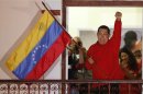 Venezuelan President Hugo Chavez waves the national flag while celebrating from a balcony at Miraflores Palace in Caracas