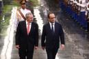 French President Francois Hollande (R) and Cuban President Raul Castro review an honor guard at the Revolution Palace in Havana on May 11, 2015