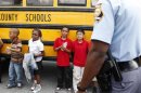 Children stand outside of their school bus after they were bused to a local Walmart following an shooting incident at McNair Discovery Learning Academy in Decatur