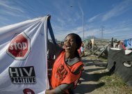A woman holds aloft an AIDS awareness banner s activists and school children march through Khayelitsha, in Cape Town