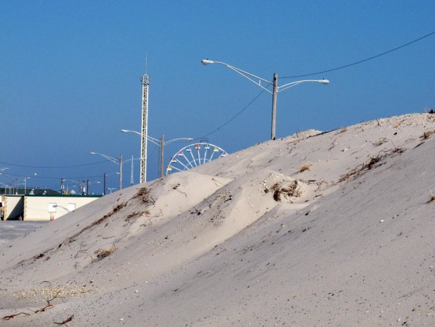 In this Feb. 15, 2013 photo, one of the well-established sand dunes in Seaside Park N.J., is shown that helped protect oceanfront homes during Superstorm Sandy, while its neighbor to the north, Seaside Heights, suffered catastrophic damage without dunes. Sandy showed how dunes protect homes along the coast, yet not all oceanfront property owners want them, fearing lost waterfront views and fearing that giving the government permission to build bigger dunes could lead to construction of boardwalks or amusements behind their pricey homes. (AP Photo/Wayne Parry)
