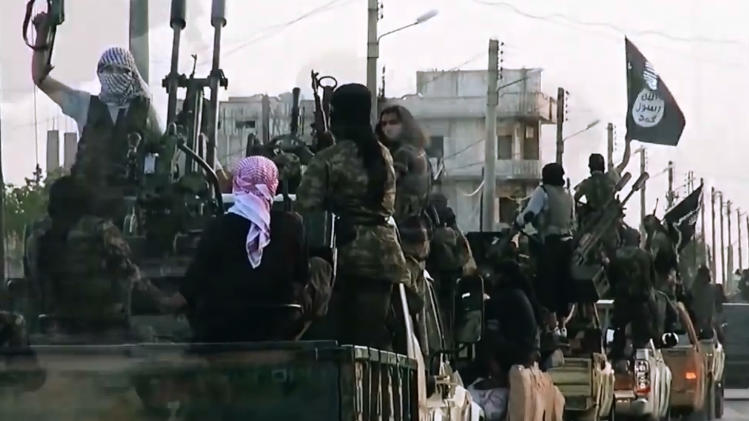 An image grab taken from a propaganda video released on March 17, 2014 by the Islamic State of Iraq and the Levant (ISIL)'s al-Furqan Media allegedly shows ISIL fighters driving on a street in the northern Syrian City of Homs