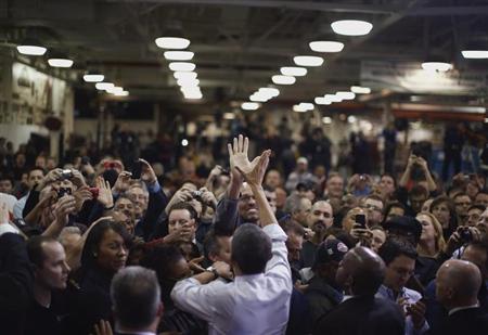 U.S. President Barack Obama high-fives an employee of the Daimler Detroit Diesel plant following remarks and a tour in Redford, Michigan, December 10, 2012. REUTERS/Jason Reed