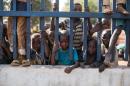 Children stand behind the fence of the French military base camp in Bossangoa on December 18, 2013