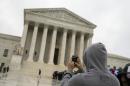 This April 29, 2014 file photo shows a Supreme Court visitor using his cellphone to take a photo of the court in Washington. A unanimous Supreme Court says police may not generally search the cellphones of people they arrest without first getting search warrants. The justices say cellphones are powerful devices unlike anything else police may find on someone they arrest. (AP Photo, File)
