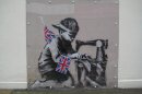 This is an undated image of an art work from British artist Banksy made available by Haringey Council Wednesday Feb. 20, 2013. The stencil by the famed, secretive graffiti artist of a young boy sewing Union Jack bunting on an antique sewing machine appeared on the side of a north London bargain store last May. Soon the gritty Turnpike Lane area was drawing art lovers keen to see Banksy's typically cheeky take on the Diamond Jubilee celebrations of Queen Elizabeth II's 60 years on the British throne. Last week it vanished, leaving nothing but a rectangle of exposed brick — only to reappear on the website of a Miami auction house. Listed as "Slave Labor (Bunting Boy)," it is due to be sold Saturday with an estimated price of between $500,000 and $700,000. (AP Photo/Haringey Council) NO ARCHIVE