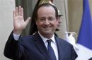 French President Hollande waves from the stairs of the entrance of the Elysee Palace in Paris after a meeting