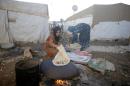 A handout picture released by Caritas Internationalis shows Syrian women preparing food at a refugee camp in in the Lebanese village of Zahle in the Bekaa valley, on June 18, 2014