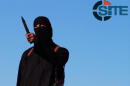 An image grab taken from a video released by the Islamic State and identified by SITE Intelligence Group on September 13, 2014 purportedly shows a masked militant before beheading British aid worker David Haines