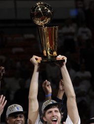 El jugador de los Mavericks de Dallas, Dirk Nowitzki, centro, levanta el trofeo de campeón de la NBA el 12 de junio de 2011 en Miami. (AP Photo/David J. Phillip, File)