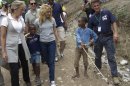 FILE - In this Sunday, April 11, 2010 file photo, Colombian singer Shakira, center left, and U.S. actor Sean Penn, right, walk with children during a visit to the makeshift camp in the Petionville Golf Club in Port-au-Prince, Haiti. The actor who stormed onto the scene of one of the worst natural disasters in history two years ago has certainly not lost interest. Defying skeptics, he has put down roots in Haiti, a country he hadn't even visited before the January 2010 earthquake, and has become a major figure in the effort to rebuild. (AP Photo/Ramon Espinosa)