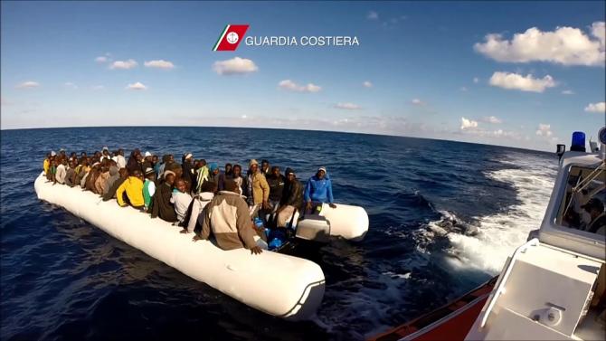 In this video grab released by the Italian Coast Guards (Guardia Costiera) on December 24, 2015 migrants and refugees sit in a boat during a rescue operation, off the coast of Sicily