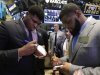 NFL draft prospects DJ Fluker, left, from Alabama, and Sheldon Richardson, of Missouri, sign autographs during their visit to the trading floor of the New York Stock Exchange, Wednesday, April 24, 2013.  (AP Photo/Richard Drew)
