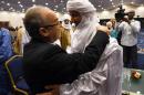 Algerian Foreign Minister Ramtane Lamamra (L) hugs Mali's Bilal Acherif, the general secretary of the National Movement for the Liberation of Azawad, during a peace agreement ceremony on March 1, 2015 in Algiers