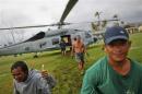 Survivor of Typhoon Haiyan gestures after receiving aid delivered by a U.S. military helicopter to a isolated village north of Tacloban