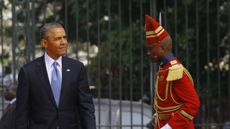 U.S. President Obama is followed by a member of honor guard at the Presidential Palace in Dakar
