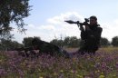 Free Syrian Army fighters hold their weapons and take positions in preparation for what they say is an ambush against forces loyal to Syria's President Bashar al-Assad in Binnish in Idlib Province