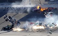 Varios pilotos, incluyendo el inglés Dan Wheldon (número 77, en el aire, a la izquierda), chocan en un accidente que involucró a 15 bólidos durante la Indy 300 de Las Vegas, el domingo 16 de octubre de 2011. Wheldon murió. (Foto AP/Las Vegas Review-Journal, Jessica Ebelhar) NO PUBLICAR EN LAS VEGAS SUN