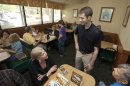 In this photo taken March 19, 2012, Republican Congressional candidate Tom Cotton, standing, greets people in a Hot Springs, Ark., restaurant. Cotton and one other Republican seeking the office in Arkansas' 4th District are veterans of the war in Afghanistan. (AP Photo/Danny Johnston)