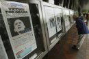 People view newspaper front pages showing Obama's win over Romney at Newseum in Washington