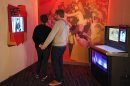 This March 26, 2012 photo shows visitors watching a display about the 1960s 'Go-Go' scene in Los Angeles, next to a vintage Rock-Ola jukebox converted to digital use, at the exhibit, 