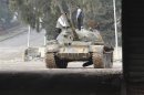 Syrian refugees play at a damaged tank near the border with Turkey at Bab El-Hawa on the outskirts of Idlib