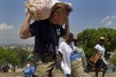 FILE - In this April 10, 2010 file photo, U.S. actor Sean Penn carries the belongings of a person displaced by the earthquake as people are relocated from the Petion ville Golf Club to a new camp, Corail-Cesselesse, in Port-au-Prince, Haiti. Penn is being honored by a group of Nobel laureates for his relief work in Haiti following the country's devastating January 2010 earthquake. Penn is to receive the 2012 Peace Summit Award at the 12th World Summit of Nobel Peace Laureates at an event in Chicago in April 2012 and is expected to draw such luminaries as Poland's Lech Walesa and the Dalai Lama. (AP Photo/Ramon Espinosa, File)