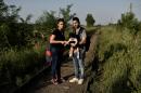 An Iraqi refugee couple, Ahmad and Alia and their four-month-old baby Adam walk on a railway line near the northern Serbian town of Horgos on September 1, 2015