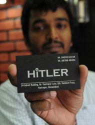 One of the two Indian owners of the 'Hitler' clothing store -- Rajesh Shah -- poses with a visiting card at his shop in Ahmedabad on August 28. Shah insisted that until the store opened he did not know who Adolf Hitler was and that Hitler was a nickname given to the grandfather of his store partner because "he was very strict"