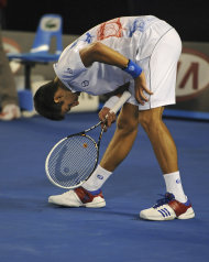 El serbio Novak Djokovic se estira durante el partido contra el español David Ferrer en los cuartos de final del Abierto de Australia el miércoles 25 de enero de 2012. (AP Foto/Andrew Brownbill)