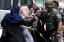 Palestinian woman argues with an Israeli border policeman near the scene where a Palestinian woman and a man, who the Israeli military said tried to stab security forces, were shot dead by Israeli police near Qalandia checkpoint near Ramallah