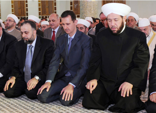 In this photo released by the Syrian official news agency SANA, Syrian President Bashar Assad, center, prays during the Eid al-Fitr prayer at Hafez al-Assad mosque, in Damascus, Syria, on Tuesday Aug. 30, 2011. Syrian security forces killed seven people on Tuesday as they opened fire to disperse thousands of protesters rallying against the regime on the first day of a Muslim holiday that marks the end of the fasting month of Ramadan, activists said. (AP Photo/SANA) EDITORIAL USE ONLY