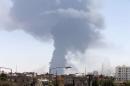 Smoke rises after rockets fired by one of Libya's militias struck and ignited a tank in Tripoli
