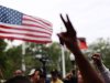 Demonstrators hold their hands aloft during a march and rally to the front of the Sanford Police Department for Trayvon Martin in Sanford, Florida