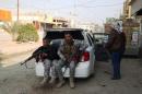 Armed tribesmen and Iraqi police sit in a car as clashes rage on in the Iraqi city of Ramadi, west of Baghdad, on January 2, 2014