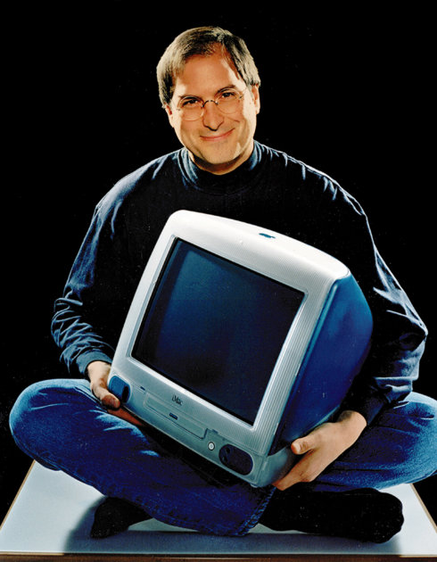FILE - This 1998 file photo provided by Apple shows Apple CEO Steve Jobs holding an iMac computer. Apple Inc. on Wednesday, Aug. 24, 2011 said Jobs is resigning as CEO, effective immediately. He will 