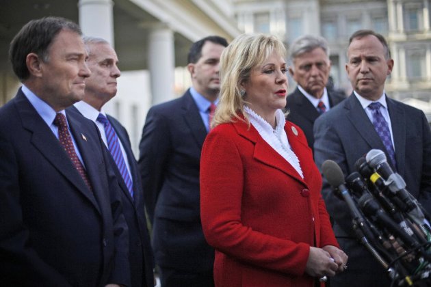 National Governors Association (NGA) Vice Chair, Oklahoma Gov. Mary Fallin, center, talks to reporters outside the White House in Washington, Tuesday, Dec. 4, 2012, following a meeting between the NGA executive committee and President Barack Obama regarding the fiscal cliff. From left are, Utah Gov. Gary Herbert, Minnesota Gov. Mark Dayton, Wisconsin Gov. Scott Walker, Fallin, Arkansas Gov. Mike Beebe, and NGA Chairman, Delaware Gov. Jack Markell. (AP Photo/Pablo Martinez Monsivais)
