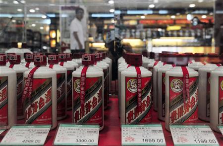A customer walks past a glass case displaying Maotai liquors, a form of baijiu, with different price tags at a supermarket in Shenyang, Liaoning province, in this August 8, 2012 file photo. Chinese baijiu, a flammable, pungent white liquor averaging a 110-proof wallop, is the world's most consumed form of liquor thanks to its popularity in China, but for the first time distillers are looking to develop export markets.REUTERS/Stringer/Files