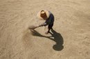File photo of a Thai farmer drying rice grains in Buriram province
