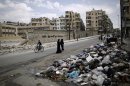 A Syrian woman looks back while walking with another woman past a pile of garbage left on a roadside in Aleppo, Syria, Tuesday, Sept. 11, 2012. (AP Photo/Muhammed Muheisen)